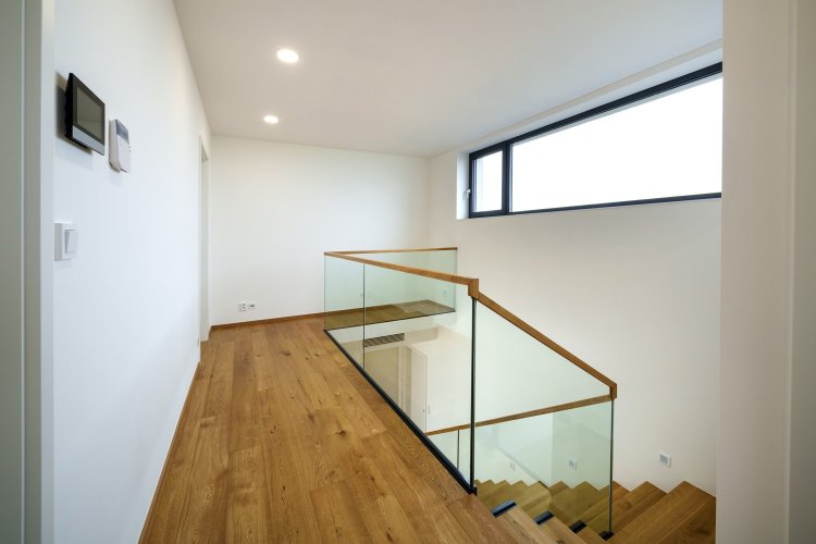 Skleněné zábradlí se skrytým kotvením v moderním domě - kolem schodiště i plošiny v patře